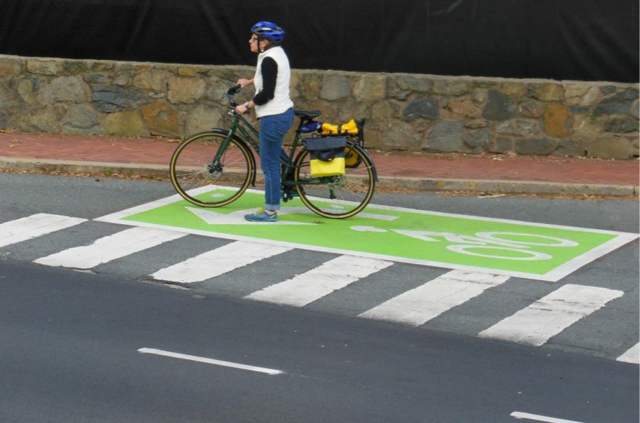 A photograph of a bicyclist waiting at a two-stage left-turn box in Charlottesville, VA.