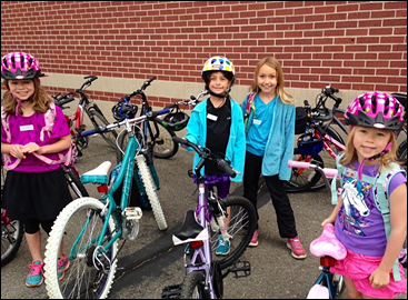 Students at Buzz Aldrin Elementary School show off their bicycles. 